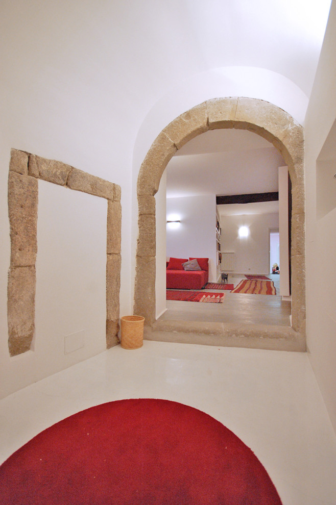 Cette image montre un vestibule bohème de taille moyenne avec un mur blanc, un sol en vinyl et une porte simple.