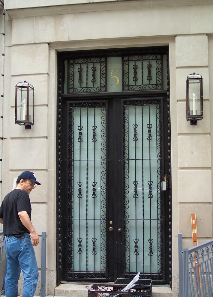 ニューヨークにあるトラディショナルスタイルのおしゃれな玄関ドア (黒いドア) の写真