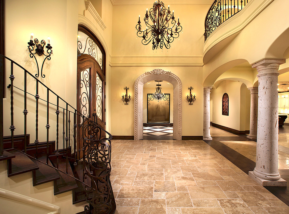 This is an example of an expansive traditional foyer in Phoenix with beige walls, travertine flooring, a double front door, a brown front door and multi-coloured floors.