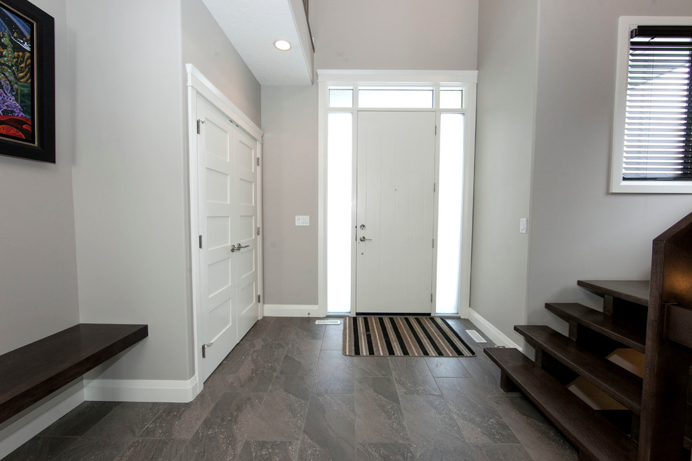 Large trendy ceramic tile entryway photo in Edmonton with gray walls and a white front door