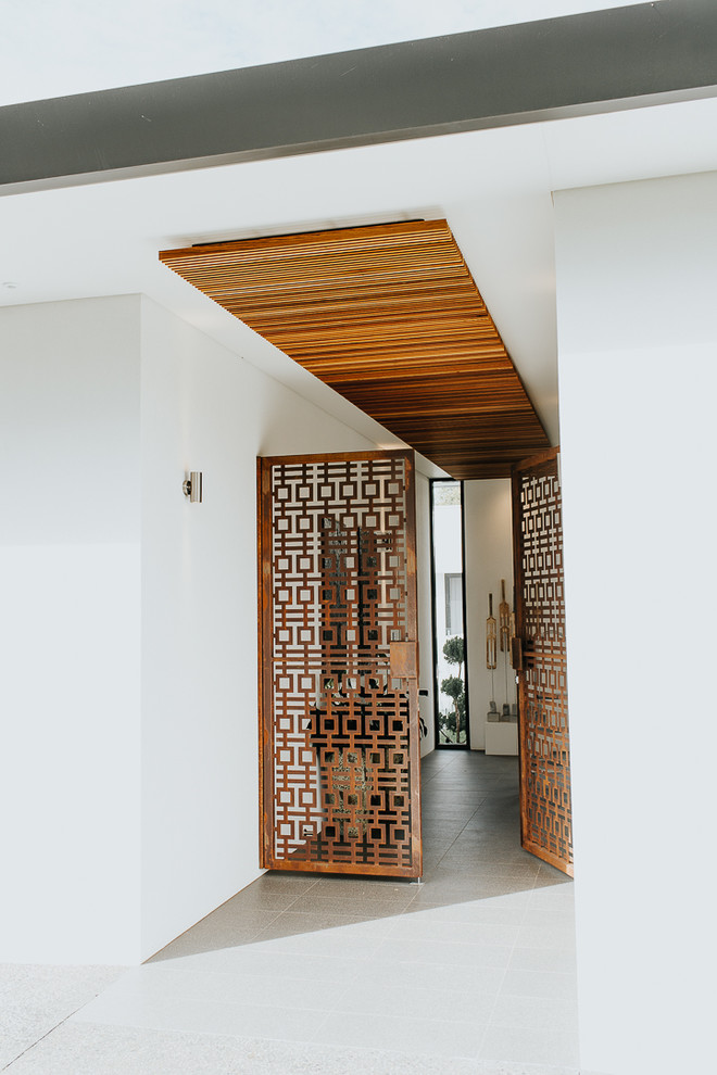 На фото: маленькое фойе в современном стиле с белыми стенами, полом из керамогранита, двустворчатой входной дверью и коричневой входной дверью для на участке и в саду с