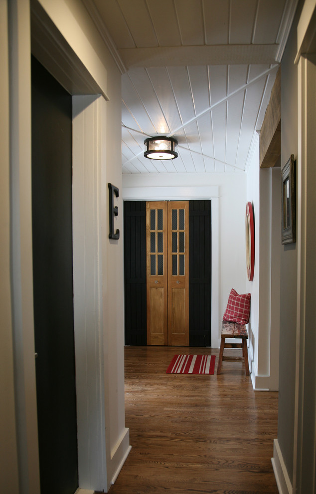 Idee per un piccolo ingresso bohémian con pareti bianche, pavimento in legno massello medio e una porta a due ante