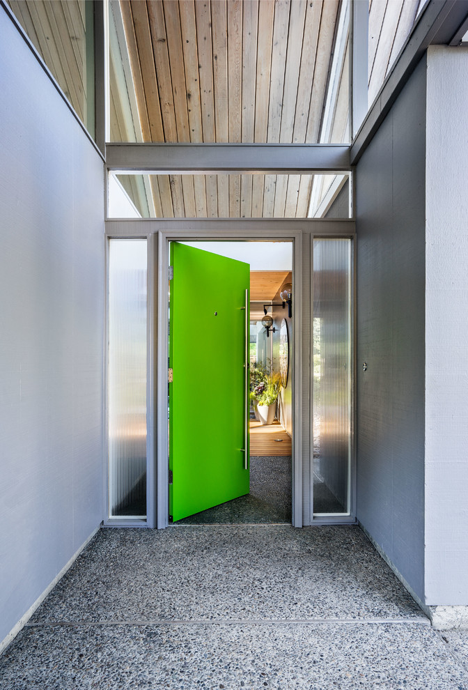 На фото: входная дверь в стиле ретро с серыми стенами, бетонным полом, одностворчатой входной дверью, зеленой входной дверью и серым полом