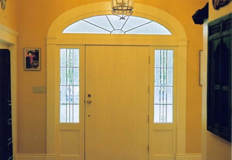 На фото: фойе среднего размера в классическом стиле с желтыми стенами, светлым паркетным полом, одностворчатой входной дверью и белой входной дверью