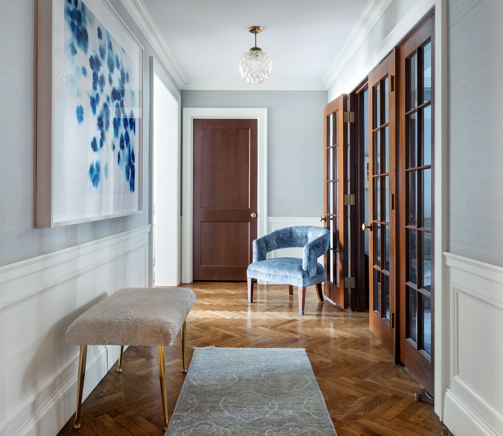 Diseño de hall clásico renovado con paredes azules, suelo de madera en tonos medios, puerta simple, puerta de madera en tonos medios y suelo marrón