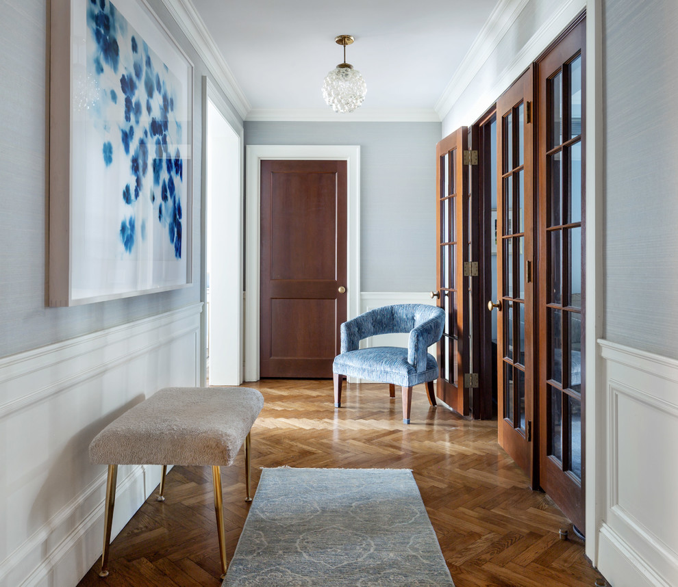 Entryway - transitional medium tone wood floor and brown floor entryway idea in New York with blue walls and a medium wood front door