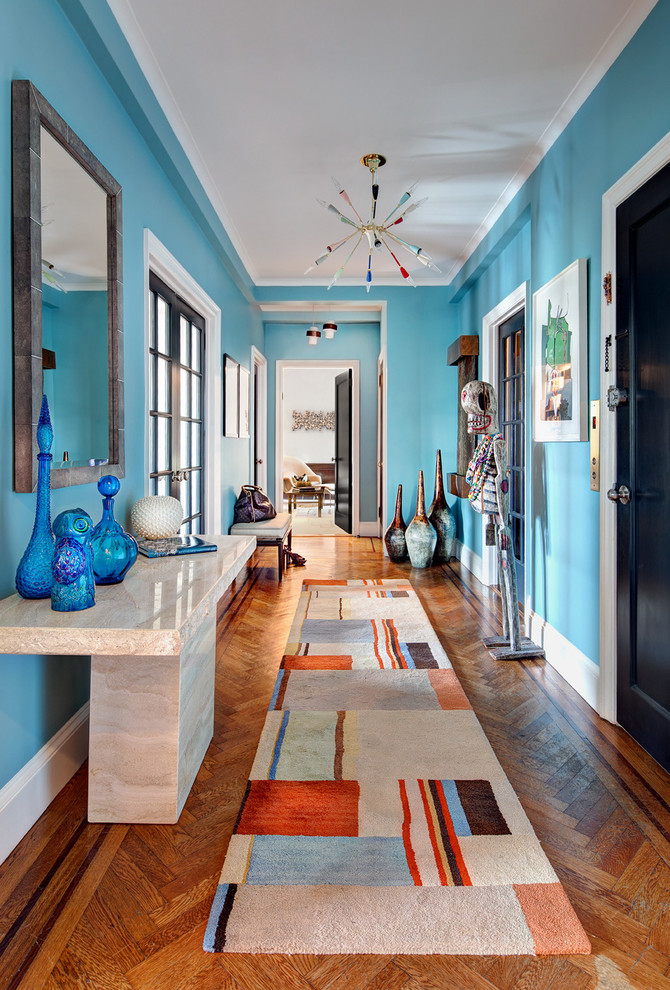 Idéer för en modern hall, med blå väggar, mellanmörkt trägolv, en enkeldörr, en svart dörr och orange golv