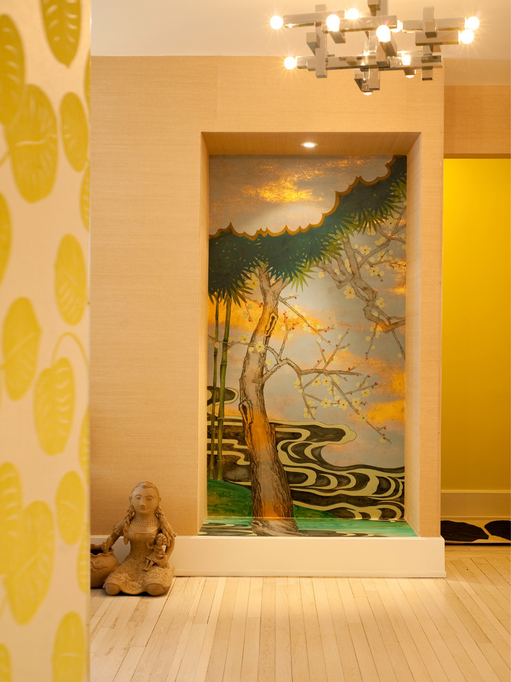 Immagine di un piccolo ingresso eclettico con pareti multicolore e parquet chiaro