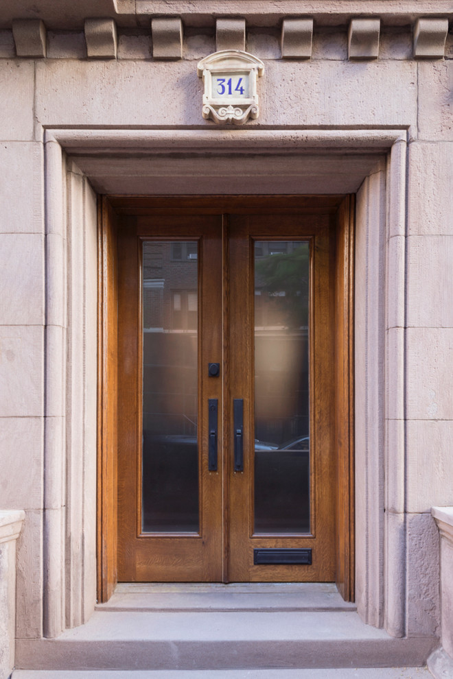 Пример оригинального дизайна: маленькая входная дверь в классическом стиле с розовыми стенами, бетонным полом, двустворчатой входной дверью, входной дверью из дерева среднего тона и серым полом для на участке и в саду