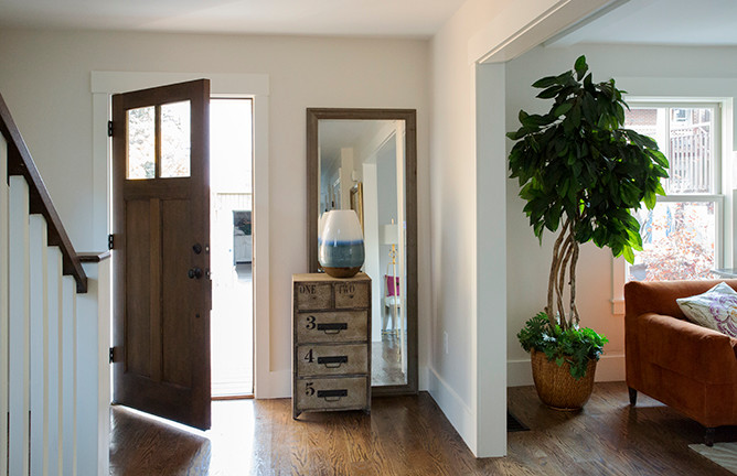 Immagine di una porta d'ingresso minimalista di medie dimensioni con una porta singola, pareti bianche e parquet scuro