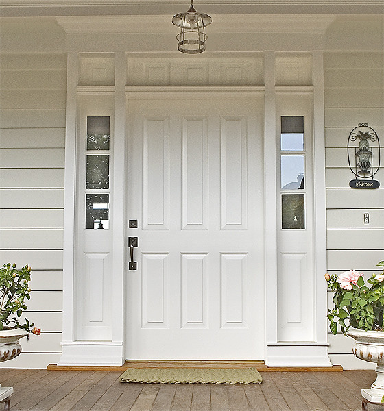 Modelo de puerta principal tradicional con puerta simple, puerta blanca, paredes blancas y suelo de madera pintada