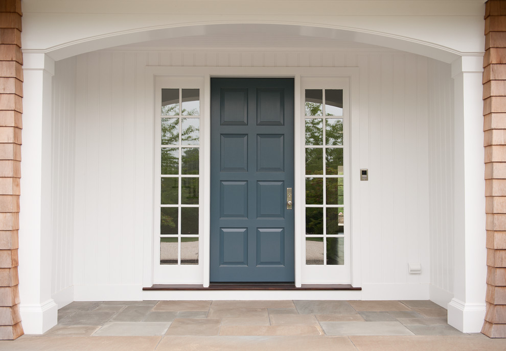 Ejemplo de puerta principal tradicional con paredes blancas, suelo de pizarra, puerta simple y puerta azul