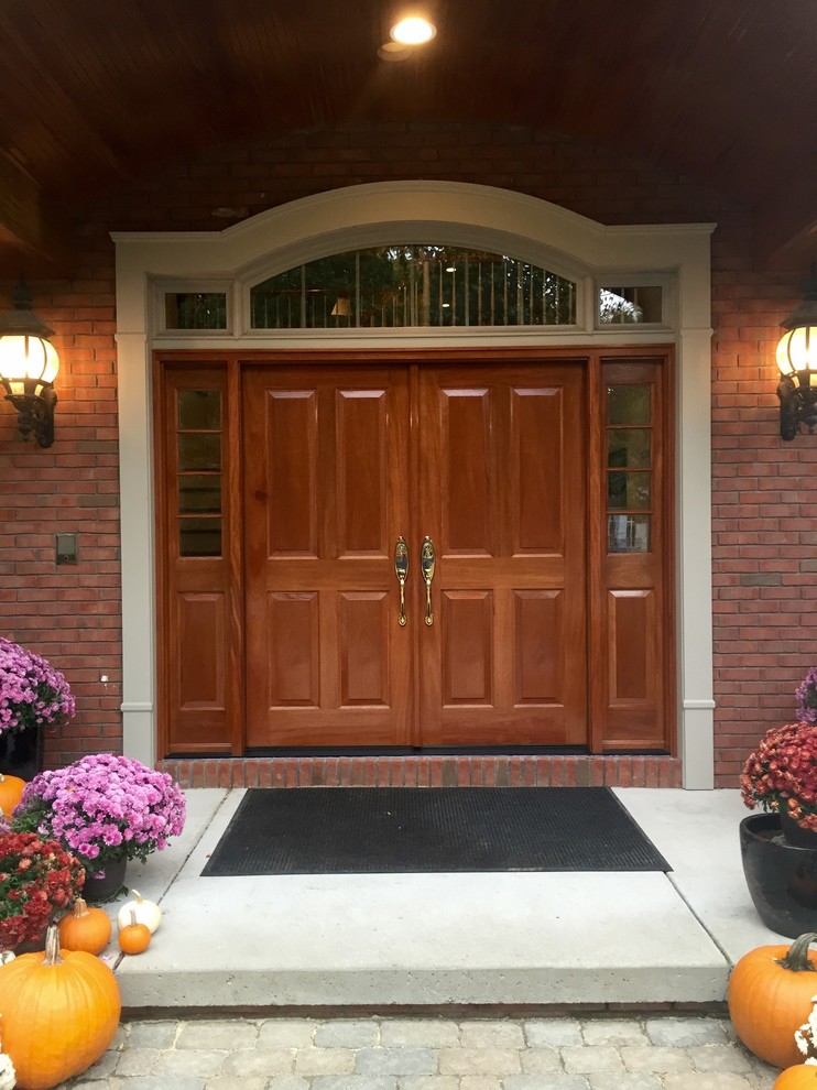 Design ideas for a large classic front door in New York with red walls, concrete flooring, a double front door and a medium wood front door.