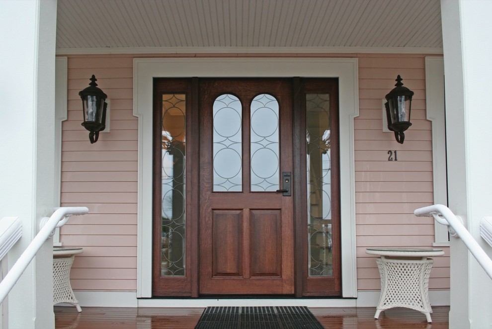 На фото: входная дверь среднего размера в классическом стиле с розовыми стенами, паркетным полом среднего тона, одностворчатой входной дверью и входной дверью из дерева среднего тона с