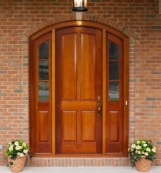 Idée de décoration pour une porte d'entrée tradition avec un mur marron, une porte simple, une porte en bois brun et sol en béton ciré.