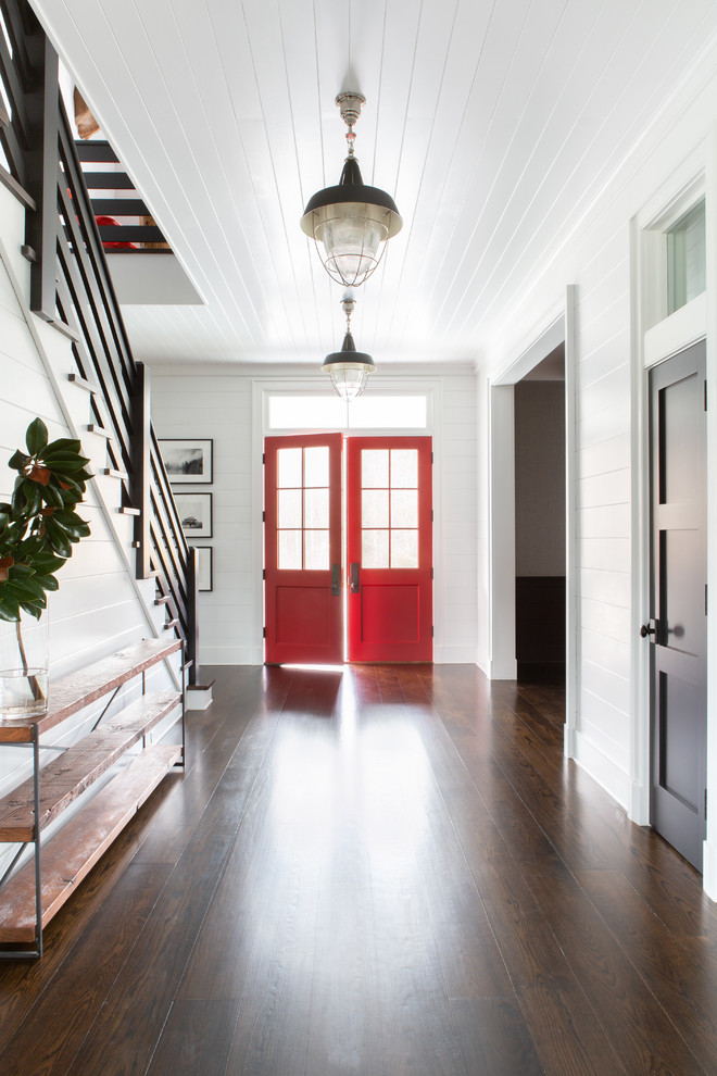 Großes Landhausstil Foyer mit Doppeltür, weißer Wandfarbe, dunklem Holzboden, roter Haustür und braunem Boden in New York