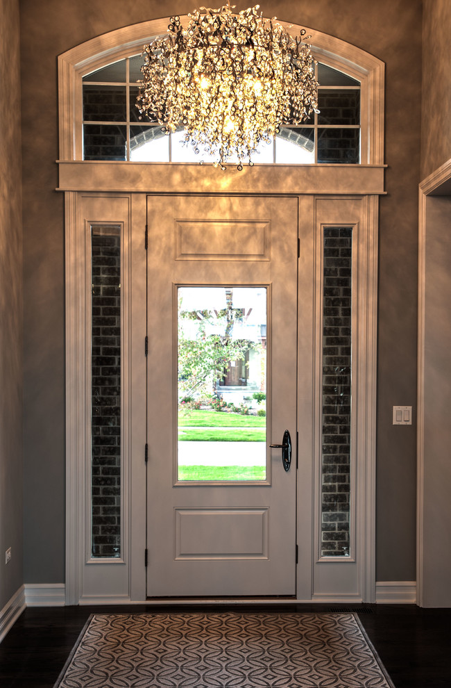 Imagen de puerta principal clásica renovada de tamaño medio con paredes grises, suelo de madera en tonos medios, puerta simple y puerta blanca