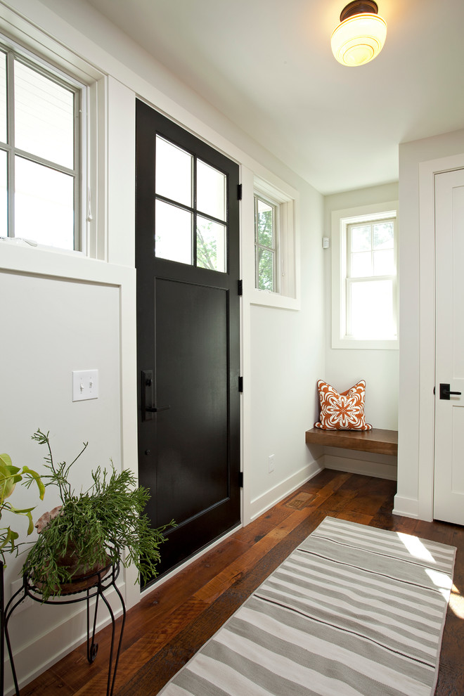 Farmhouse brown floor entryway photo in Minneapolis with white walls