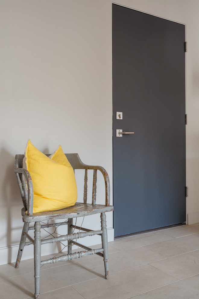 Exemple d'une entrée tendance avec parquet clair, une porte en bois clair et un mur gris.