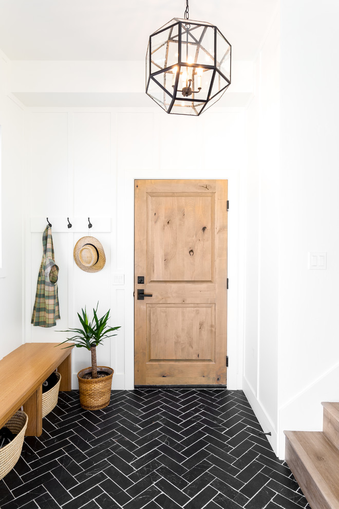 Inspiration for a medium sized country boot room in Salt Lake City with slate flooring, a single front door, a light wood front door, black floors and white walls.