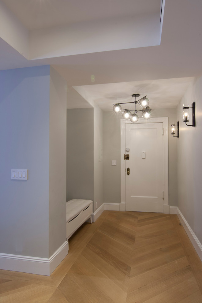 Inspiration pour un hall d'entrée design de taille moyenne avec un mur gris, parquet clair, une porte simple, une porte blanche et un sol beige.