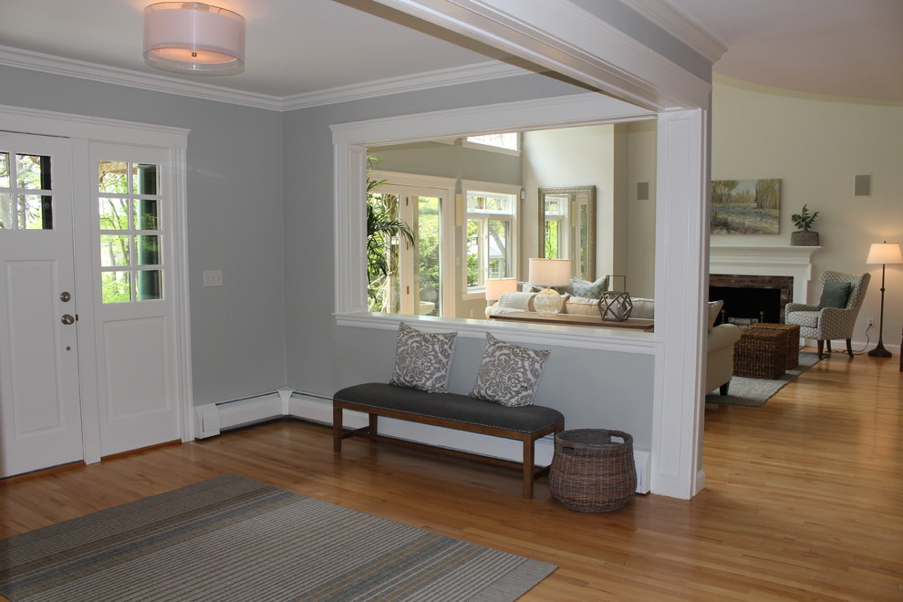 Mid-sized beach style light wood floor entryway photo in Boston with gray walls and a white front door