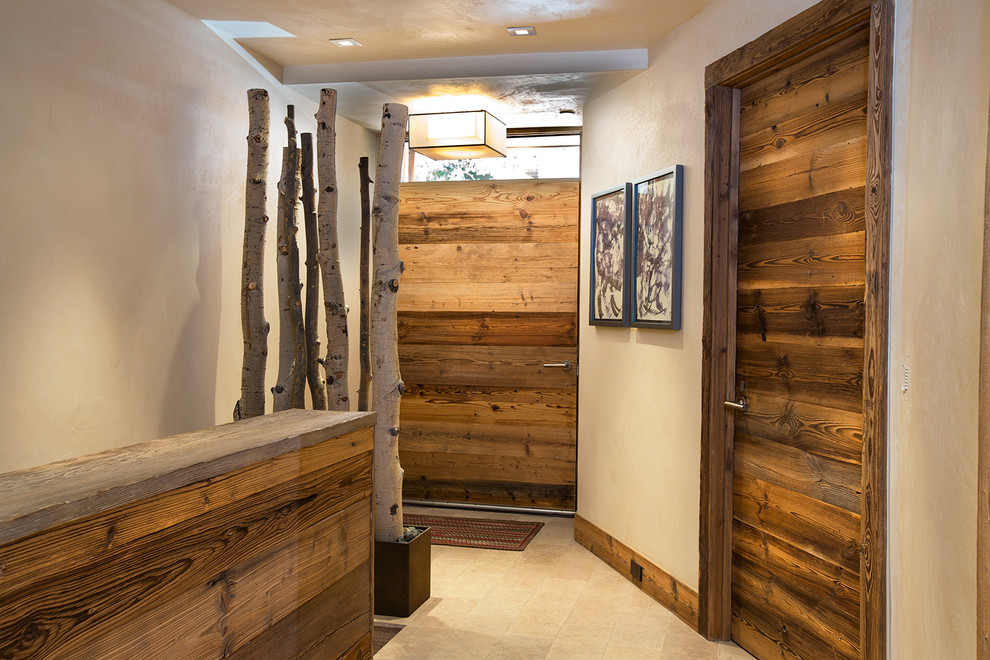 Example of a mid-sized mountain style light wood floor entryway design in Denver with beige walls and a medium wood front door