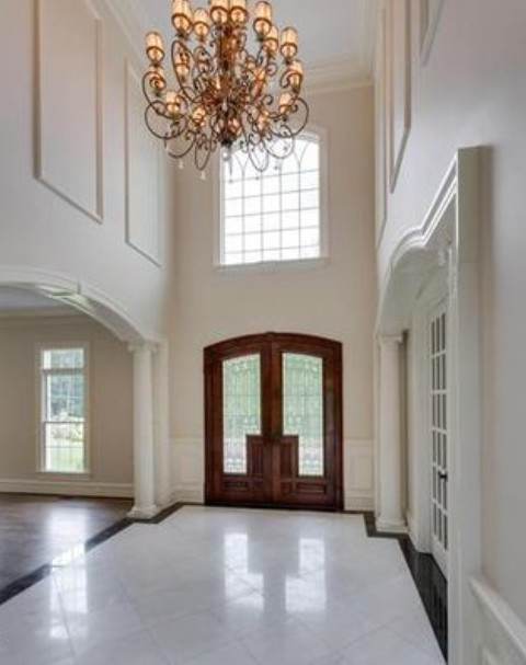 Inspiration pour un grand hall d'entrée traditionnel avec un sol en marbre, une porte double, une porte en bois brun et un mur beige.
