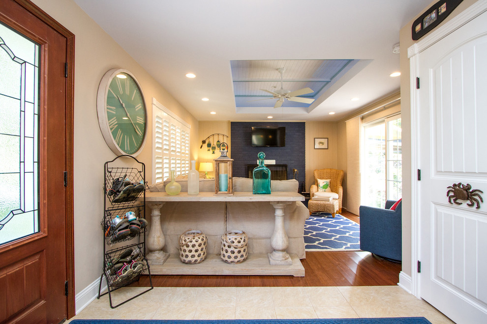 Inspiration for a mid-sized coastal medium tone wood floor and brown floor entryway remodel in Other with beige walls and a medium wood front door