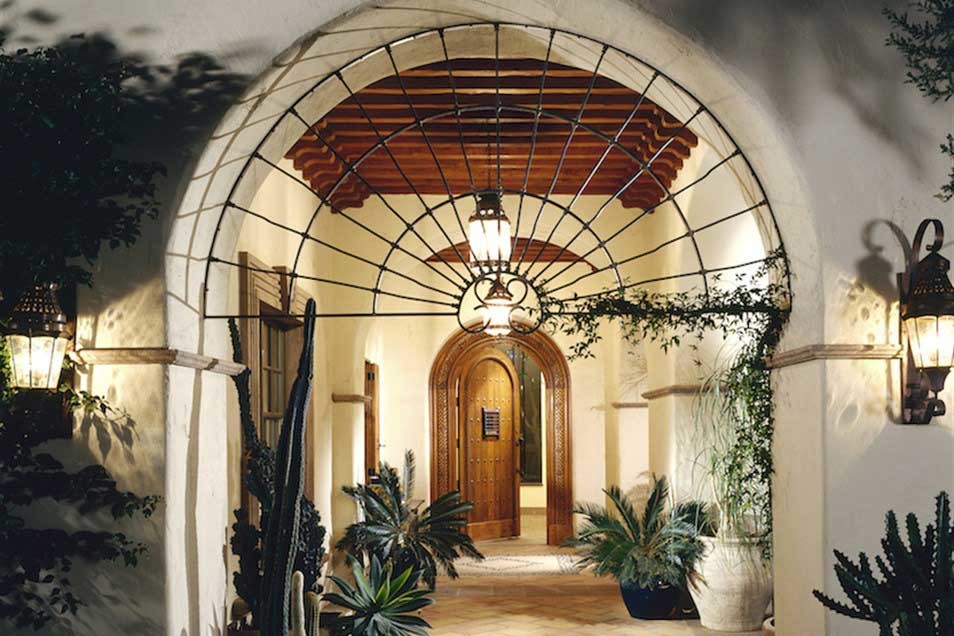 Идея дизайна: большая входная дверь в средиземноморском стиле с белыми стенами, кирпичным полом, одностворчатой входной дверью и входной дверью из дерева среднего тона