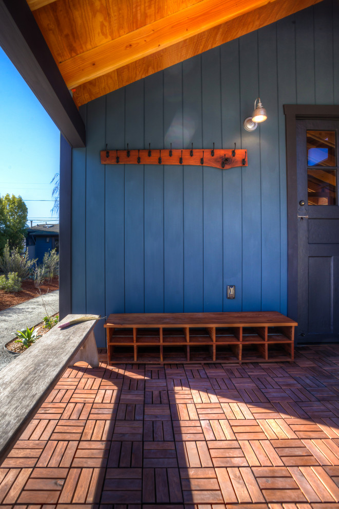 Ejemplo de puerta principal de estilo de casa de campo de tamaño medio con paredes azules, suelo de madera en tonos medios, puerta simple y puerta negra