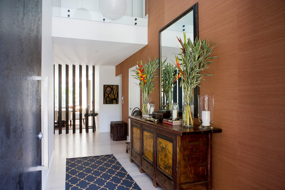 Photo of a contemporary hallway in Sydney with orange walls, light hardwood flooring and white floors.