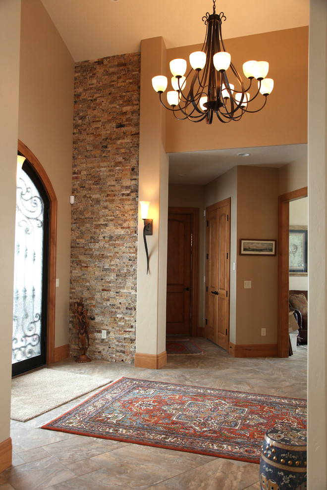 ソルトレイクシティにある高級な広いトラディショナルスタイルのおしゃれな玄関ロビー (ベージュの壁、磁器タイルの床、金属製ドア) の写真