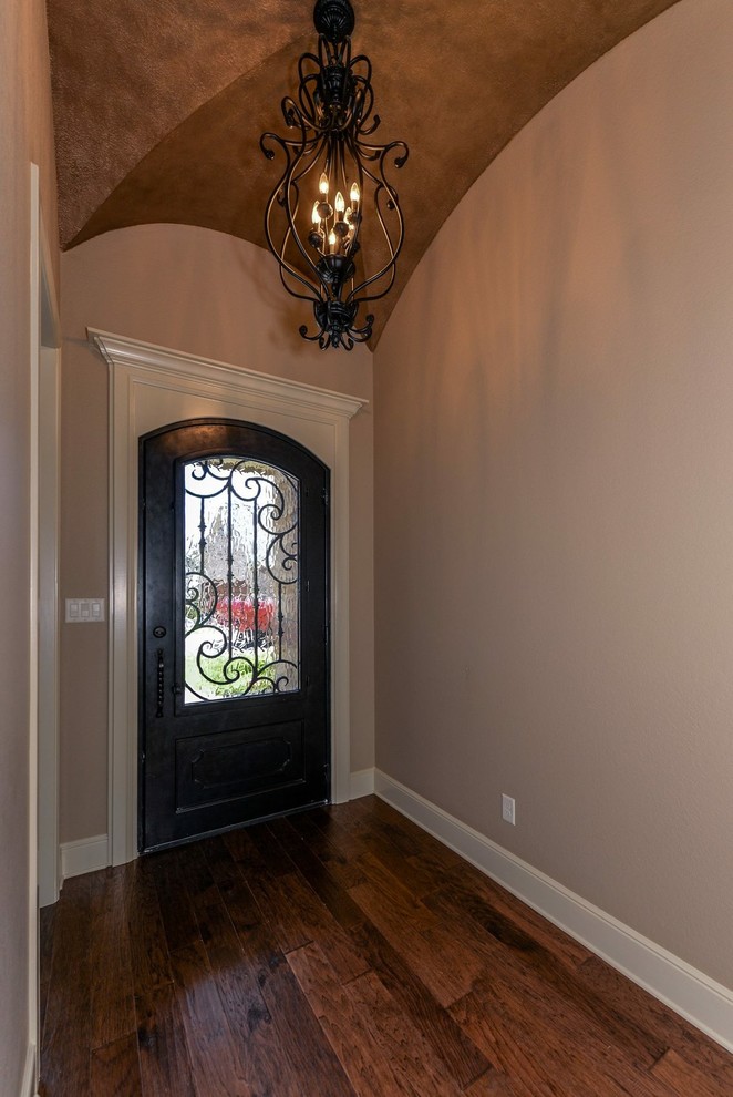Bild på en mellanstor rustik foajé, med beige väggar, mörkt trägolv, en enkeldörr, en svart dörr och brunt golv
