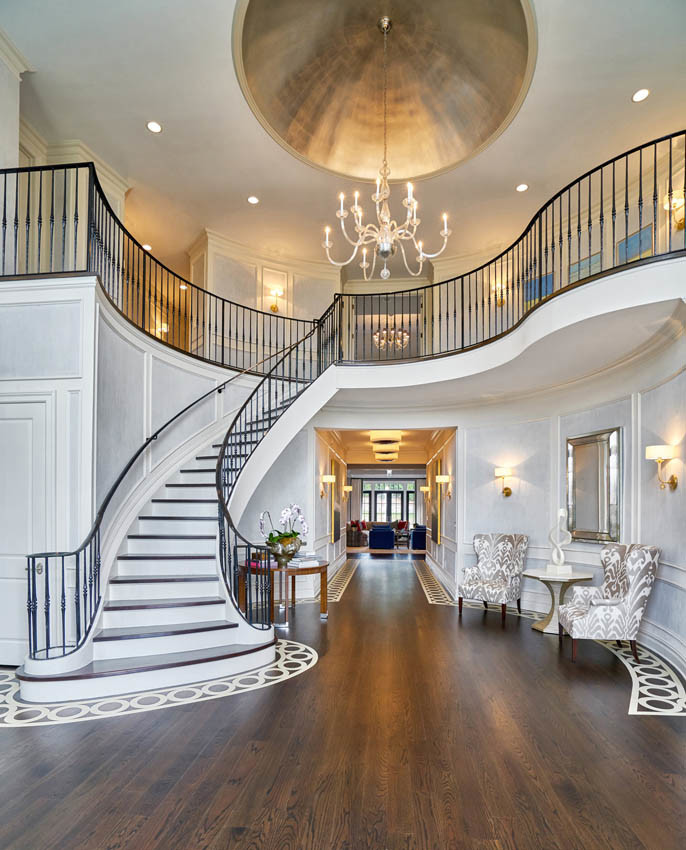 Photo of a large traditional foyer with white walls and painted wood flooring.