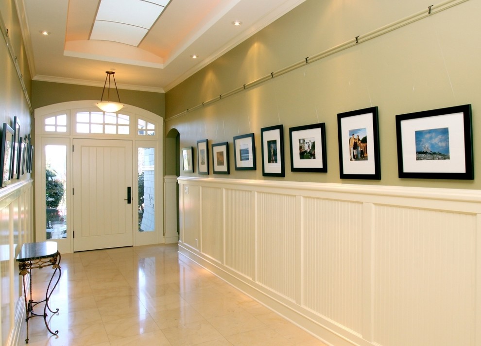 Ispirazione per un ingresso o corridoio american style con pareti verdi, pavimento in marmo, una porta singola e una porta bianca