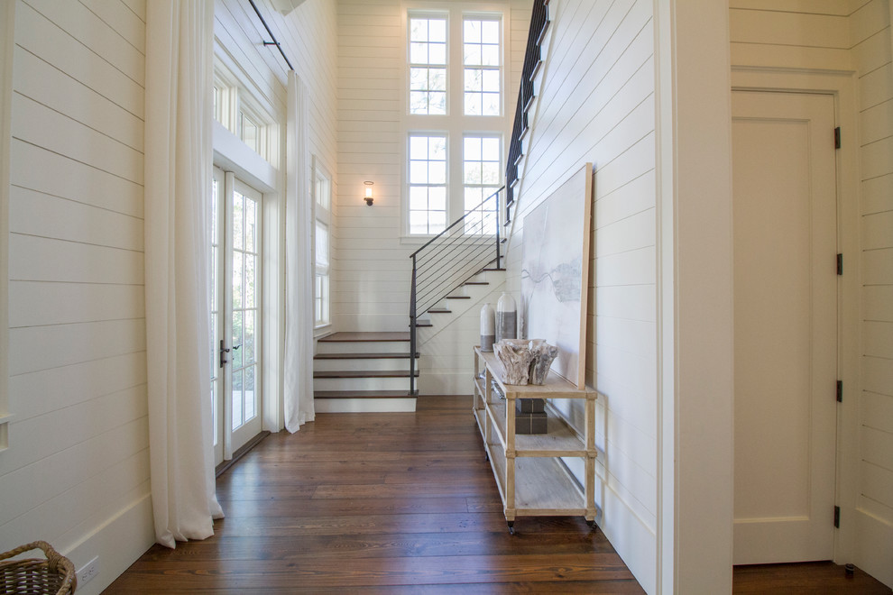 На фото: входная дверь в морском стиле с белыми стенами, темным паркетным полом, двустворчатой входной дверью и белой входной дверью