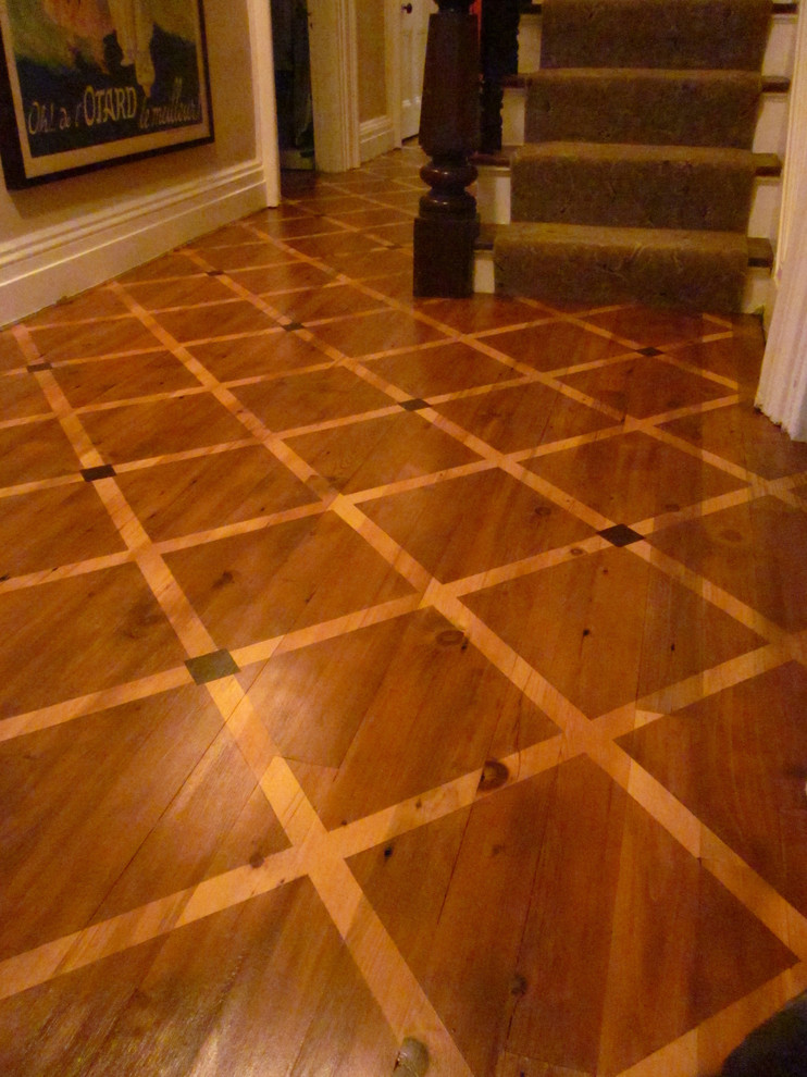 This is an example of a large traditional foyer in New York with beige walls and painted wood flooring.