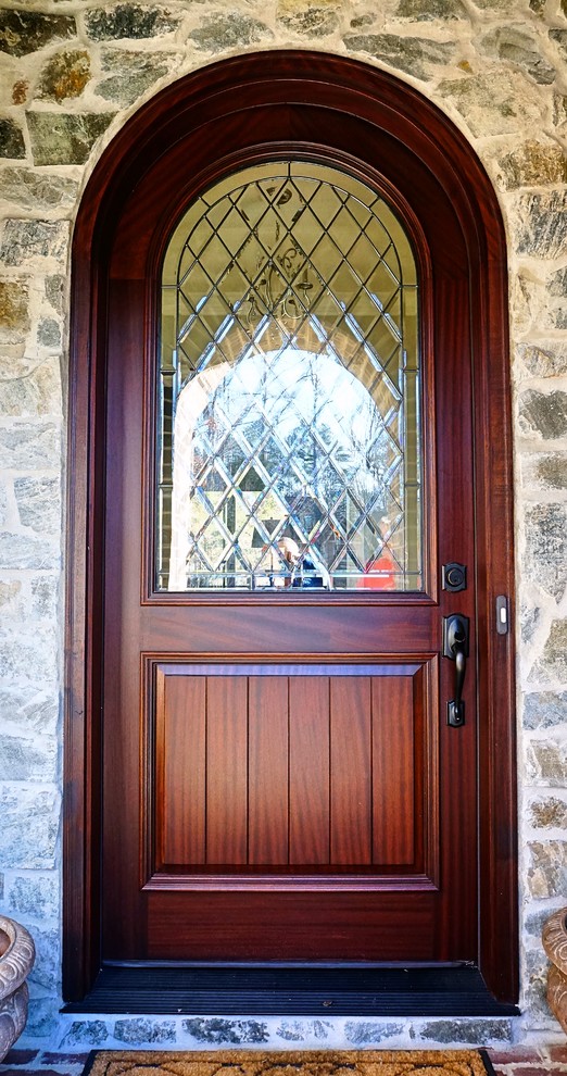 Стильный дизайн: большая входная дверь в стиле неоклассика (современная классика) с одностворчатой входной дверью и входной дверью из темного дерева - последний тренд