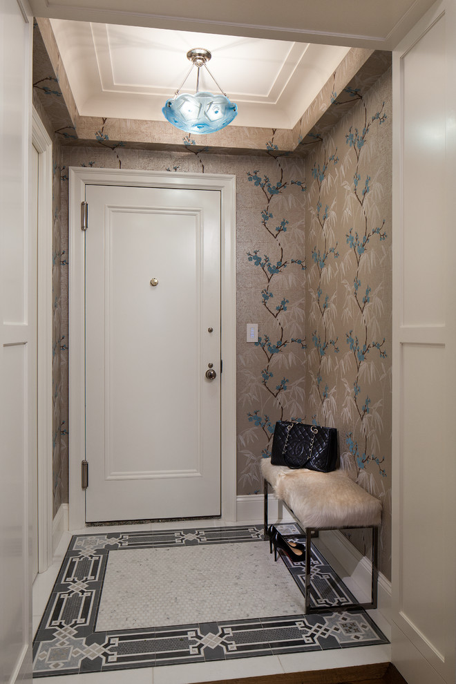 This is an example of a small traditional foyer in New York with multi-coloured walls, marble flooring and a single front door.