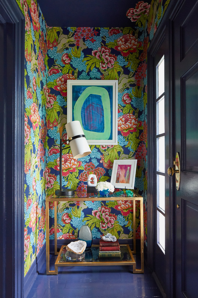 Cette image montre une petite entrée traditionnelle avec un mur multicolore, une porte simple, une porte bleue, un sol bleu et un couloir.