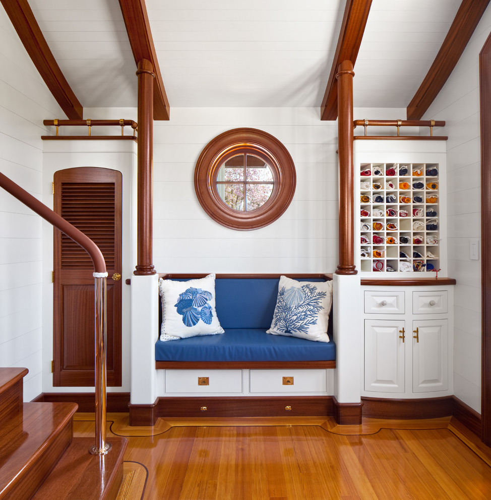 Modelo de vestíbulo posterior marinero con paredes blancas y suelo de madera en tonos medios