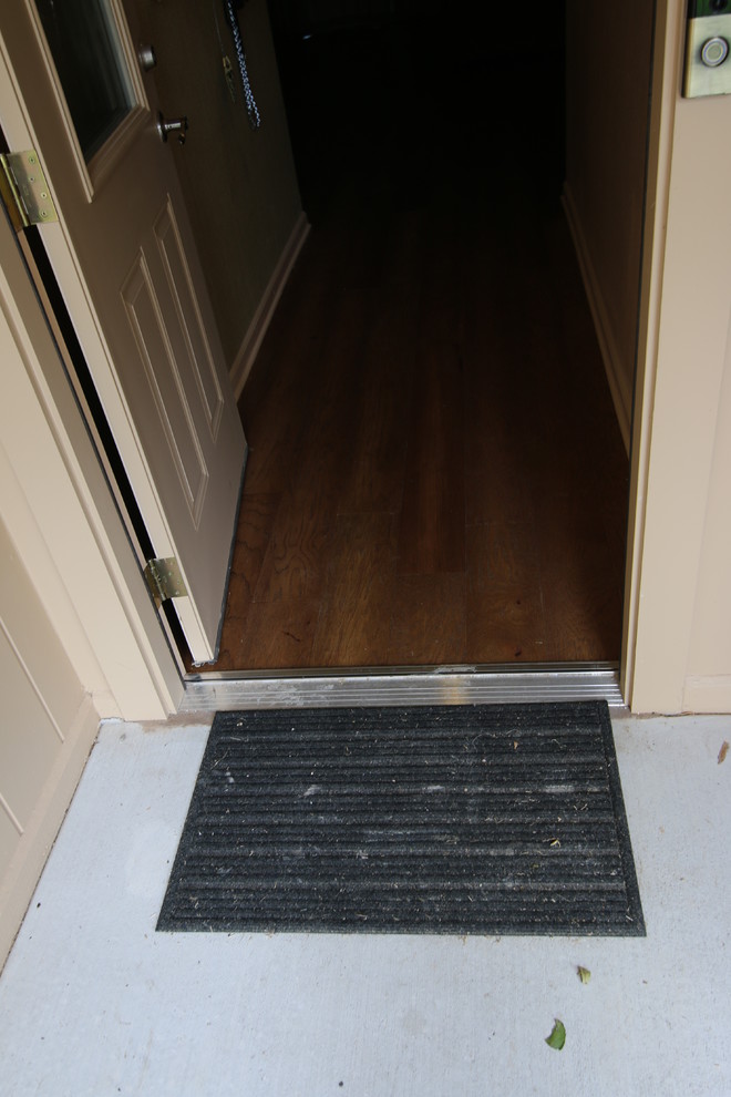 Idee per una porta d'ingresso classica di medie dimensioni con parquet scuro, una porta singola, una porta in metallo e pavimento marrone