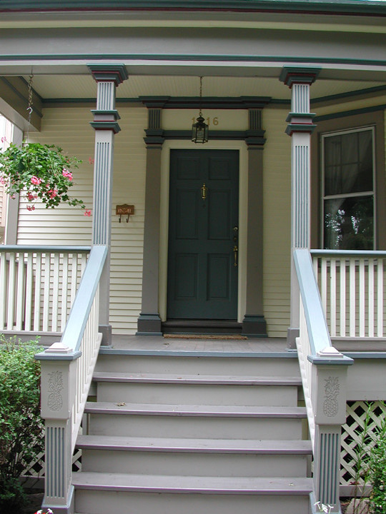 На фото: входная дверь среднего размера в викторианском стиле с бежевыми стенами, одностворчатой входной дверью и синей входной дверью