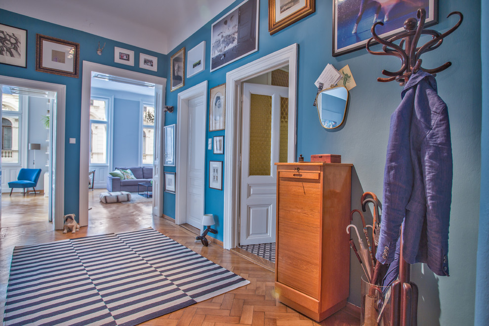 Mid-sized eclectic light wood floor foyer photo in Other with blue walls
