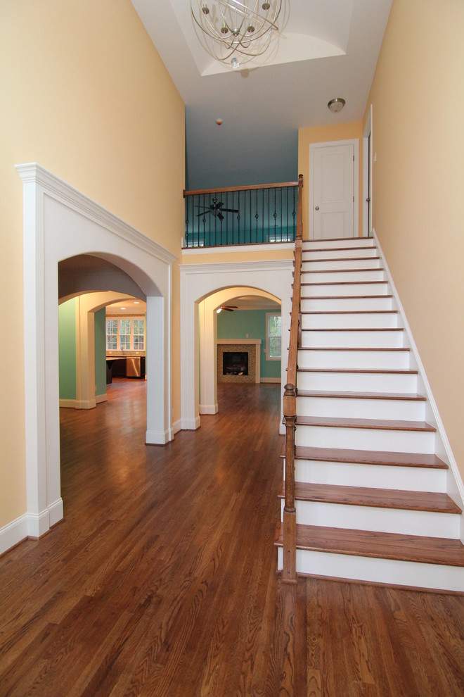 Inspiration for a large transitional dark wood floor entryway remodel in Raleigh with yellow walls and a white front door