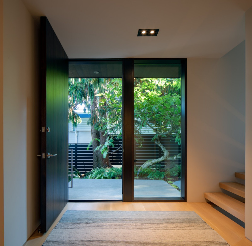Inspiration for a contemporary medium tone wood floor and wood wall single front door remodel in Seattle with a dark wood front door