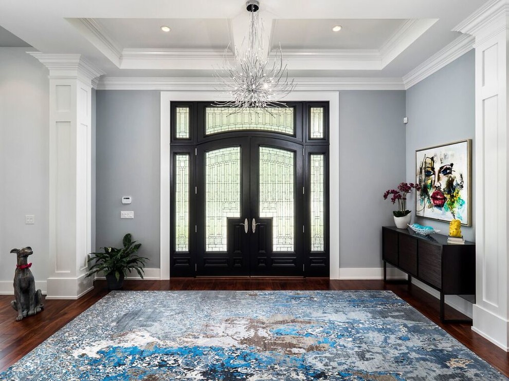 На фото: большое фойе в стиле неоклассика (современная классика) с синими стенами, паркетным полом среднего тона, двустворчатой входной дверью и черной входной дверью