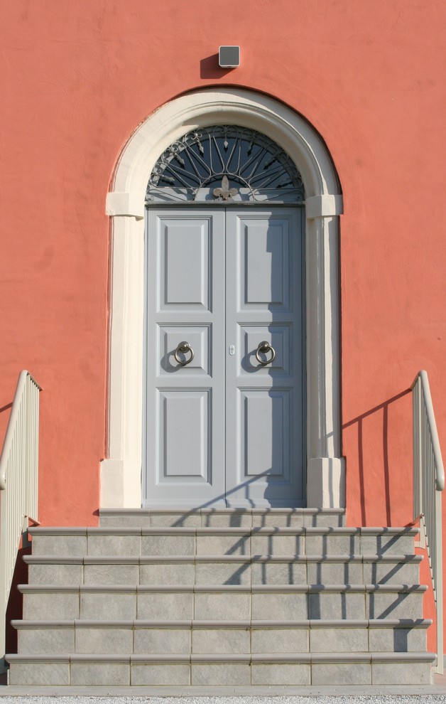 Foto di un ingresso country con pareti rosse e una porta a due ante