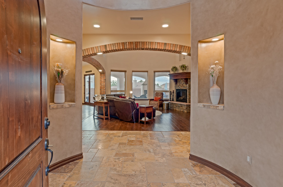 Großes Mediterranes Foyer mit beiger Wandfarbe, Terrazzo-Boden, Einzeltür und hellbrauner Holzhaustür in Albuquerque